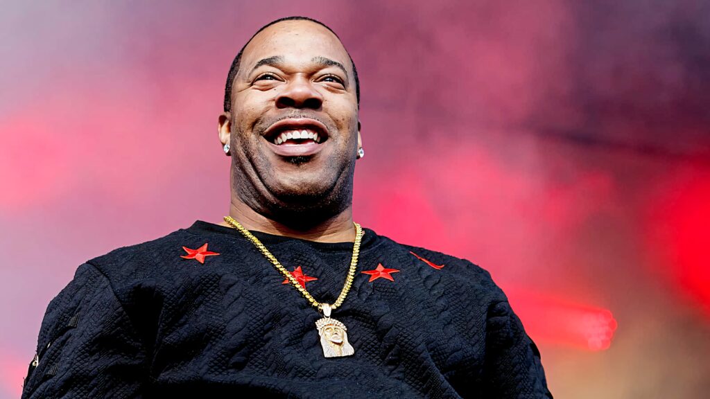 Busta Rhymes energetic live performance wallpaper with red purple background and hip hop style
