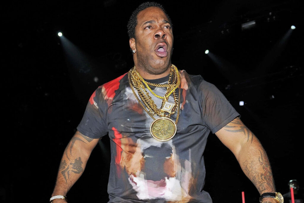 Busta Rhymes performing live hip hop concert energetic bold gestures vibrant shirt gold chains Wallpaper