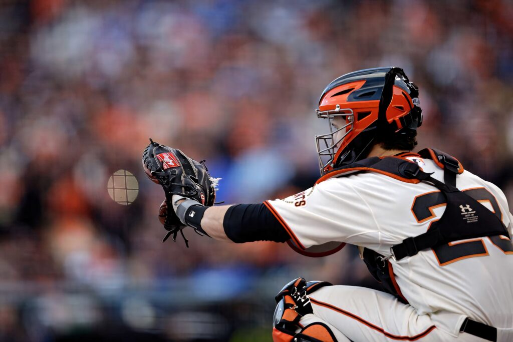 Buster Posey in full catcher gear action shot vivid orange black white detailed uniform textures Wallpaper