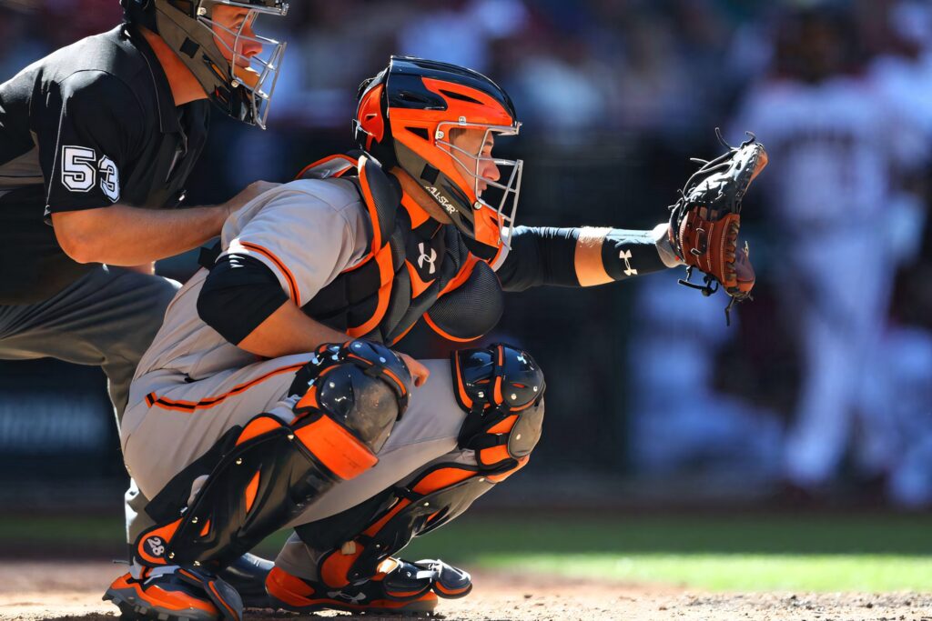 Buster Posey in vibrant orange and black catcher's gear focused behind home plate baseball wallpaper