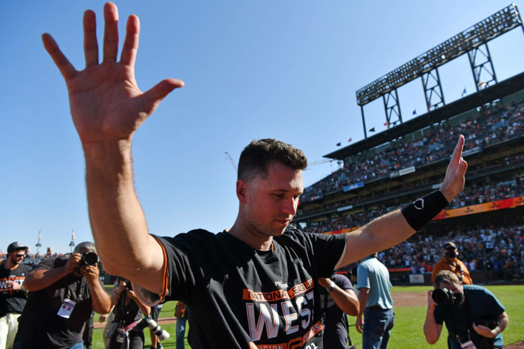 Buster Posey celebrates on baseball field with cheering crowd under clear blue sky wallpaper background