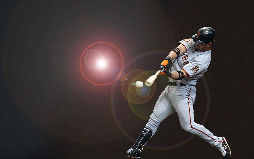 Buster Posey mid-swing baseball action wallpaper with dramatic lens flare and dark background