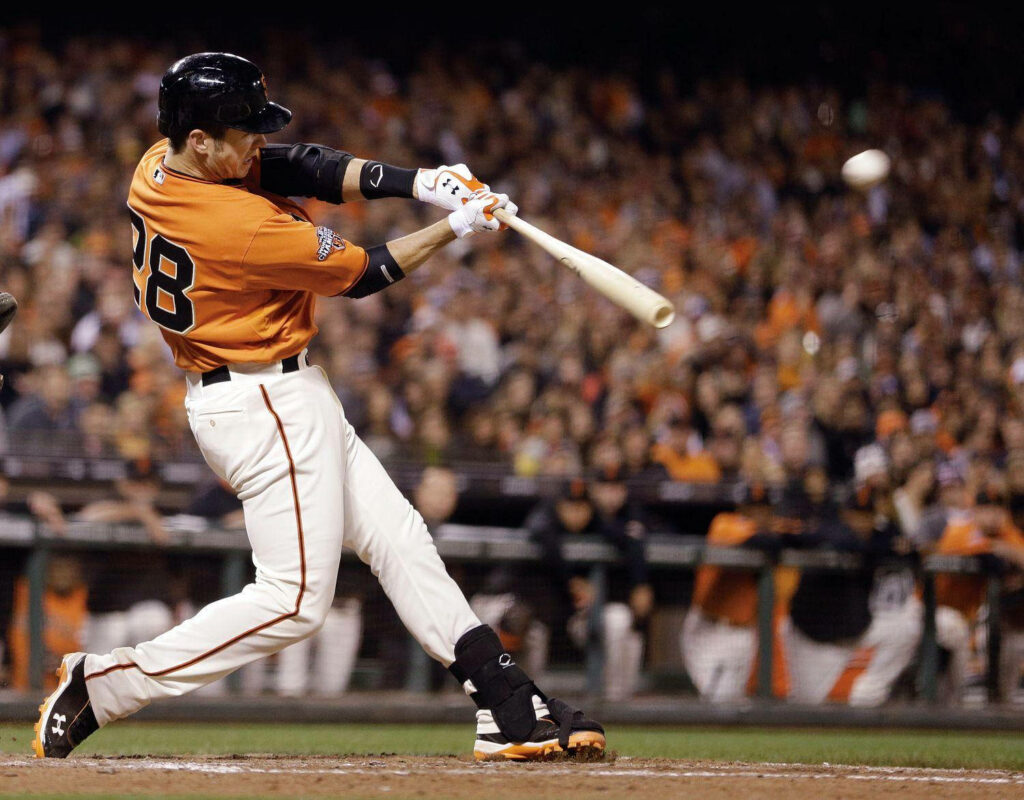 Buster Posey swinging for a fly ball in vibrant San Francisco Giants uniform during game Wallpaper