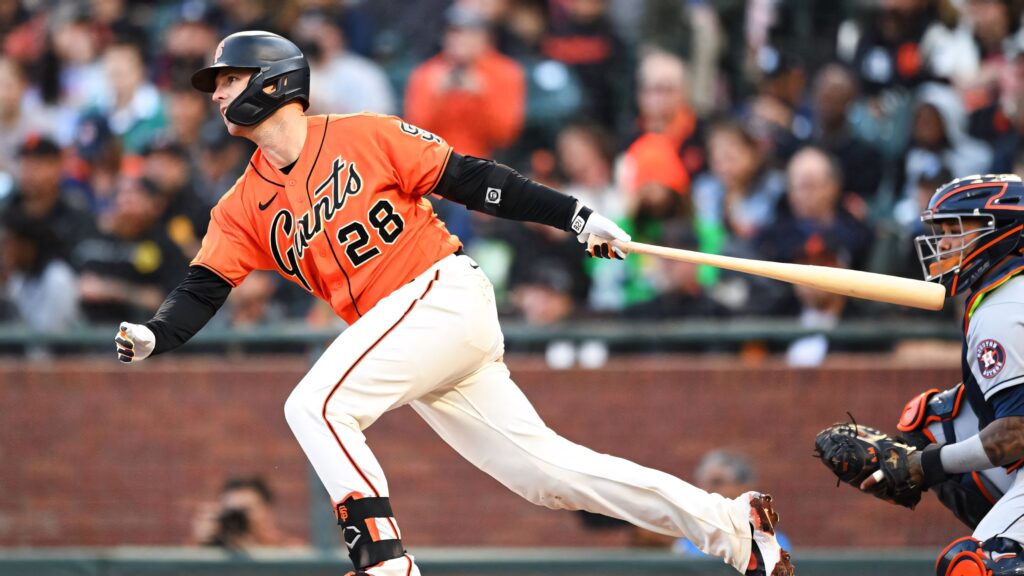 Buster Posey swinging in orange Giants jersey showing focus and energy in dynamic baseball game Wallpaper