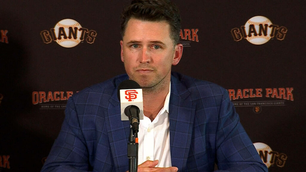 Buster Posey at Oracle Park press conference in blue checked suit with Giants and Oracle Park logos Wallpaper
