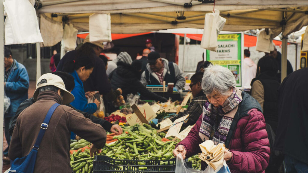 Vibrant Marketplace: Fresh Produce & Plastic Bags Wallpaper Background