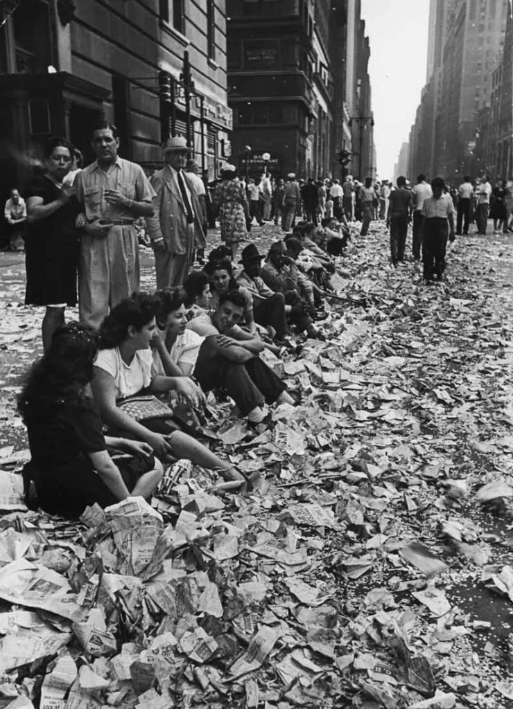 Vintage Urban Street Scene: Lively Crowd Amidst Paper Debris Wallpaper