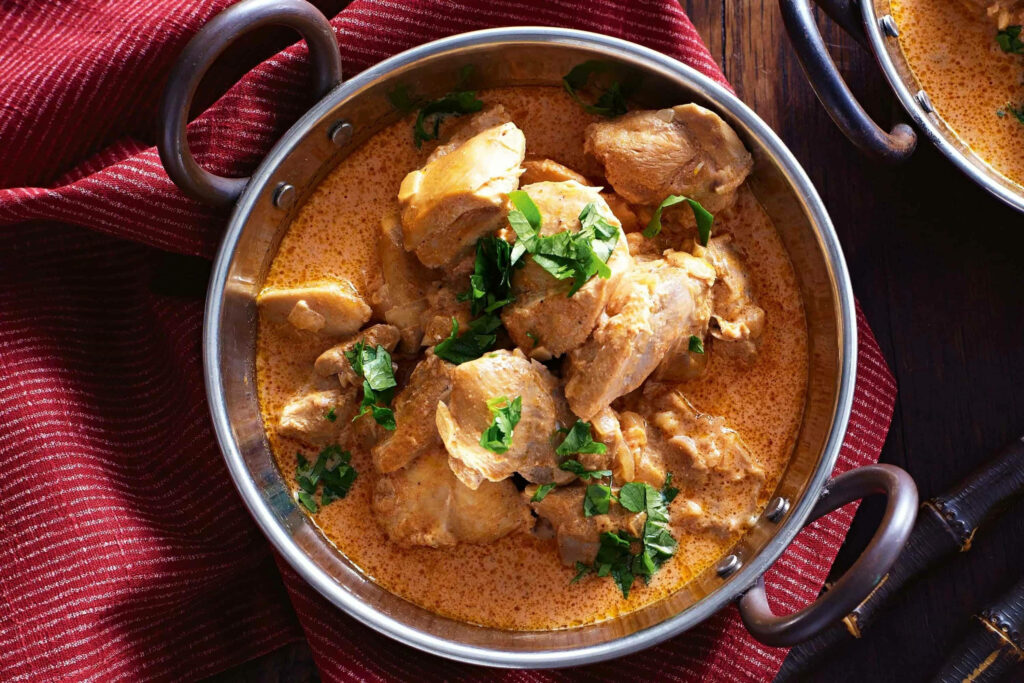 Creamy butter chicken in rich orange sauce garnished with fresh cilantro Indian cuisine wallpaper