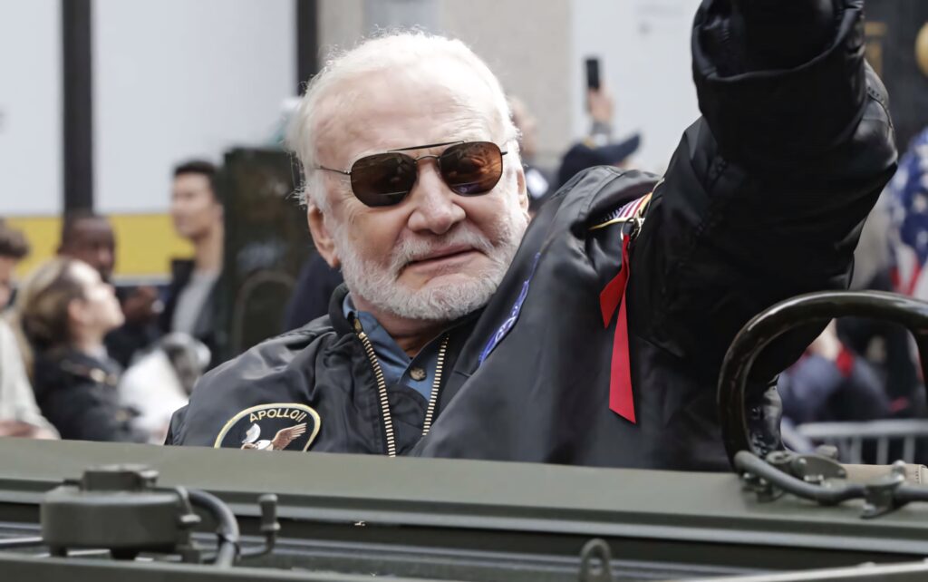 Buzz Aldrin Apollo astronaut rides open vehicle in parade with American flags and cheering crowds Wallpaper