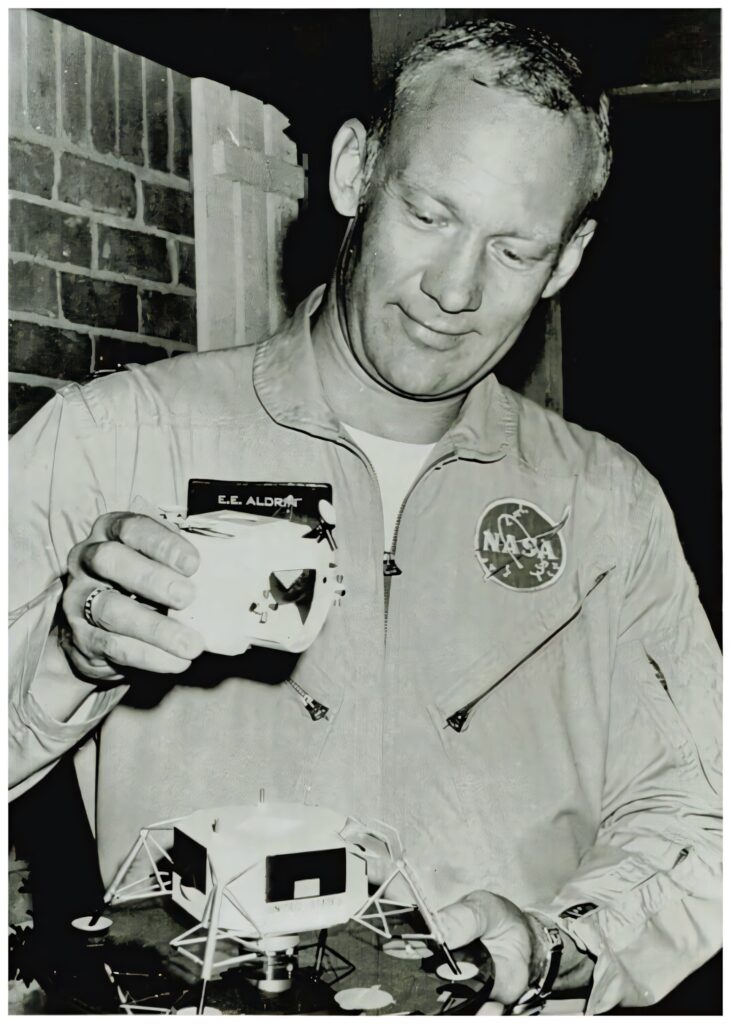 Buzz Aldrin holding detailed lunar module model wearing NASA jacket historic Apollo mission wallpaper