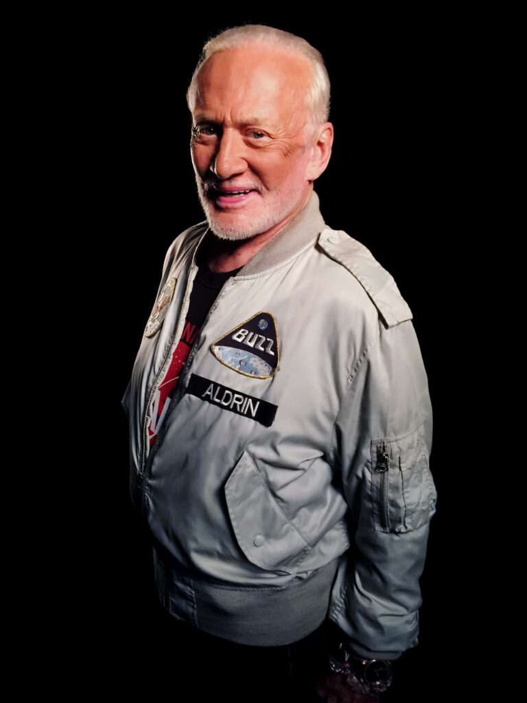Buzz Aldrin astronaut portrait in light jacket with mission patch on black background wallpaper