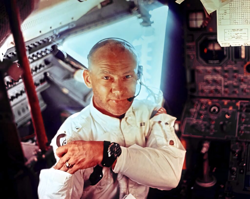 Buzz Aldrin smiling in spacecraft cockpit with vintage astronaut suit and detailed control panels Wallpaper