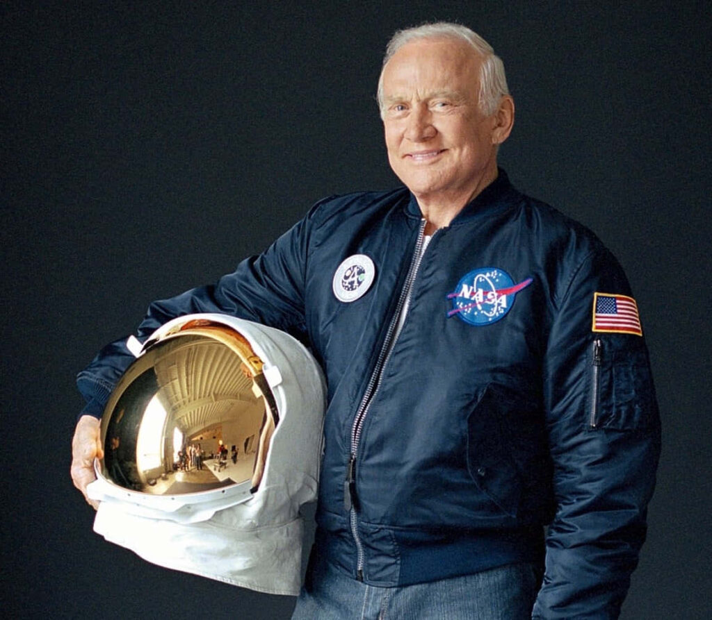 Buzz Aldrin in NASA flight jacket holding reflective space helmet Apollo astronaut wallpaper background