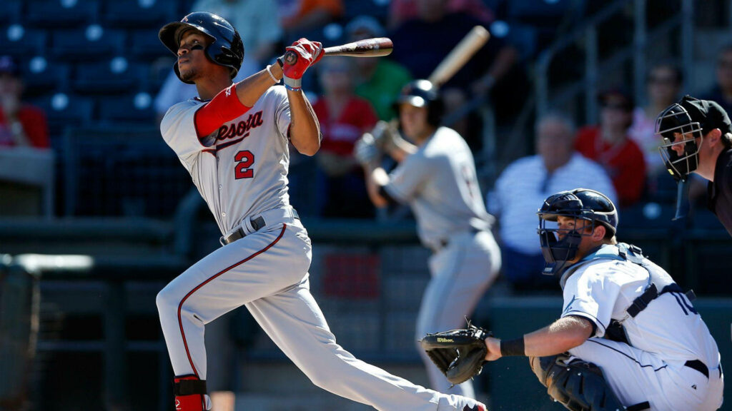 Byron Buxton swinging a bat in grey Minnesota uniform with red accents in vibrant stadium Wallpaper