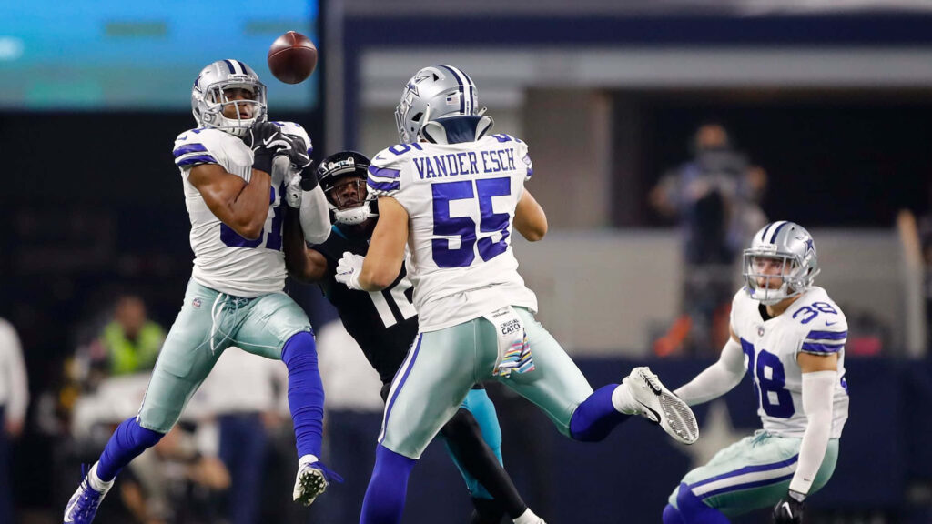 Byron Jones and Dallas Cowboys teammates in white and blue uniforms intercepting pass intense football game Wallpaper