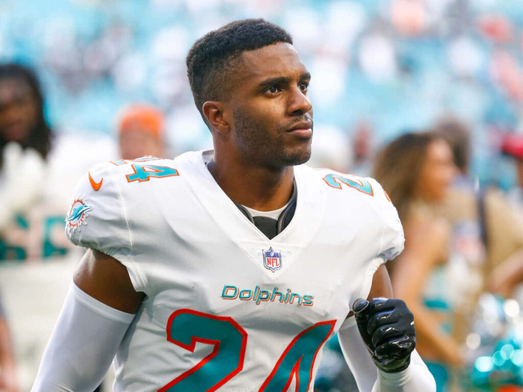 Byron Jones Miami Dolphins uniform action shot vibrant background athletic confident energy wallpaper
