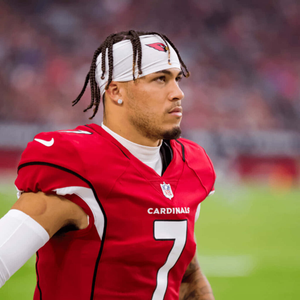 Byron Murphy in Arizona Cardinals red jersey focused on football field with vibrant stadium background Wallpaper