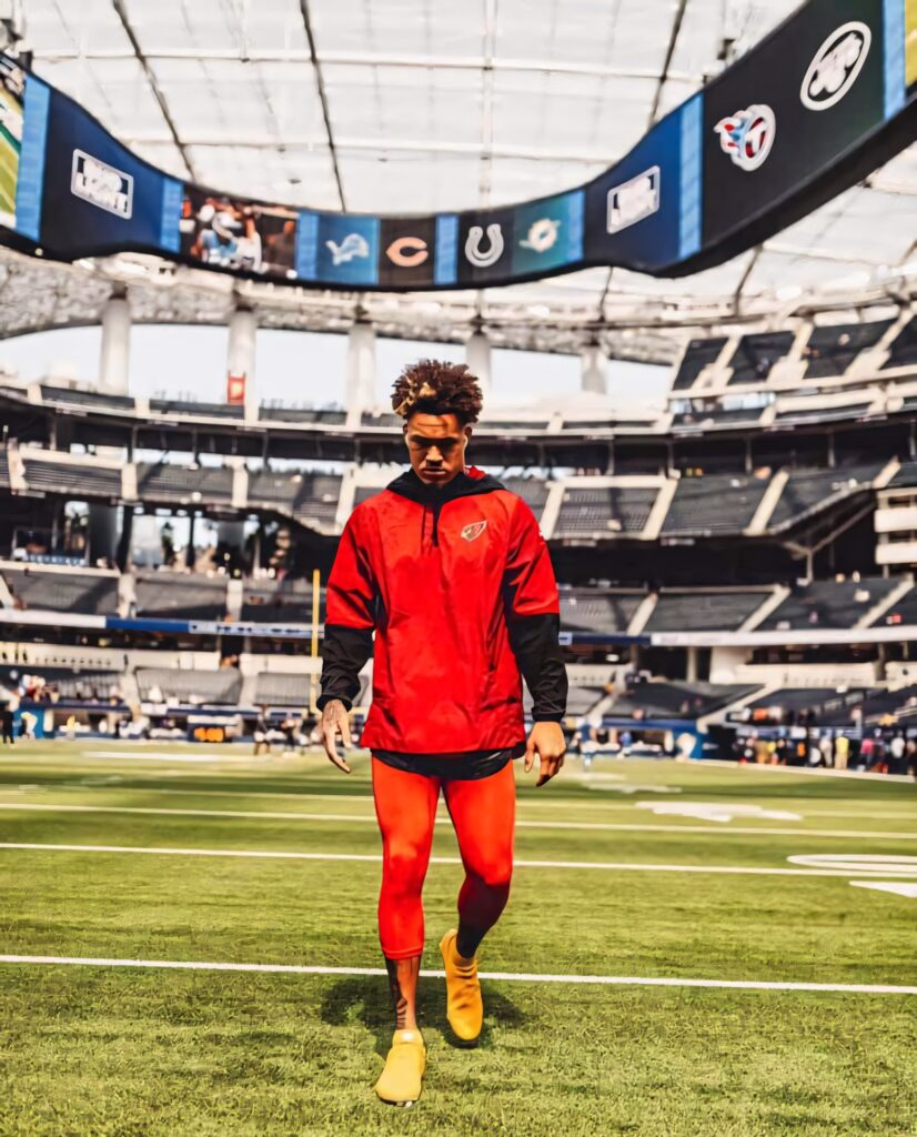 Byron Murphy in red and gold training gear focused on field under large open stadium on game day Wallpaper