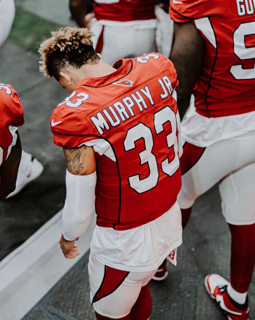 Byron Murphy in red football uniform ready for action highlighting focus and athleticism wallpaper