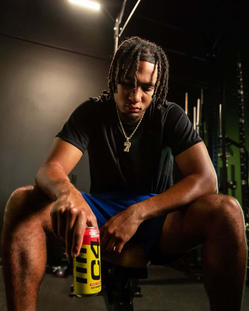 C J Stroud seated in gym with C4 energy drink showing focus strength and athletic build Wallpaper