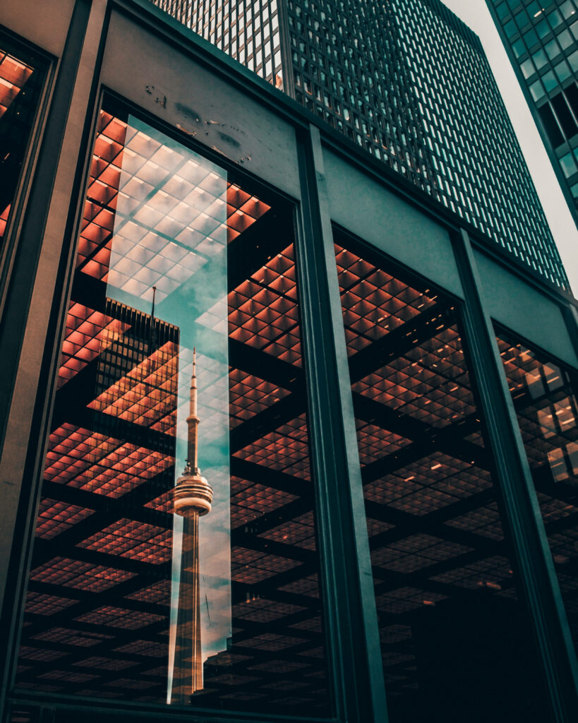 CN Tower reflected in skyscraper glass with golden lights and modern architectural lines wallpaper