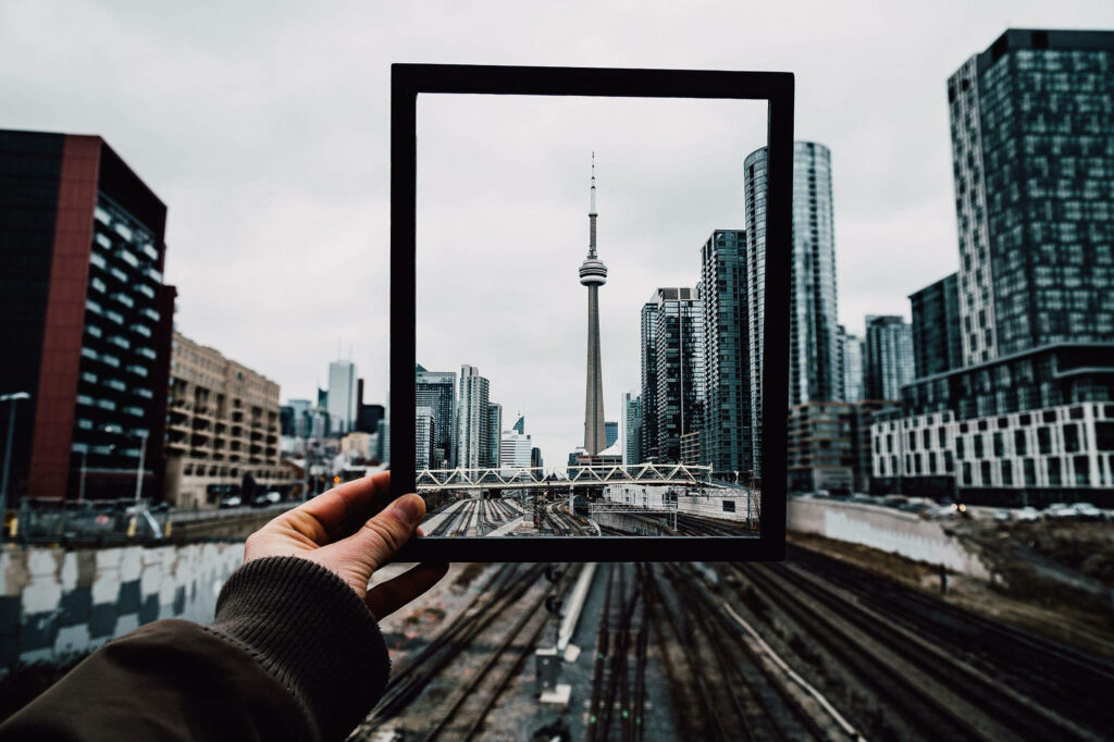 CN Tower framed handheld black frame urban skyline high-rise buildings railway tracks wallpaper