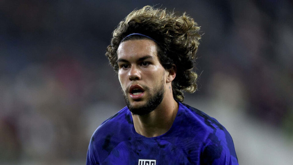 Cade Cowell intense soccer action curly hair deep blue jersey realistic stadium background wallpaper