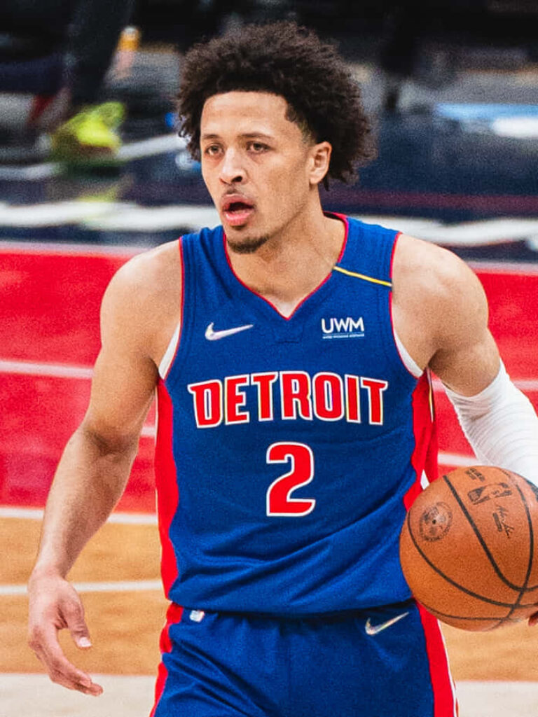 Cade Cunningham dribbling intensely in Detroit Pistons jersey dynamic basketball action wallpaper
