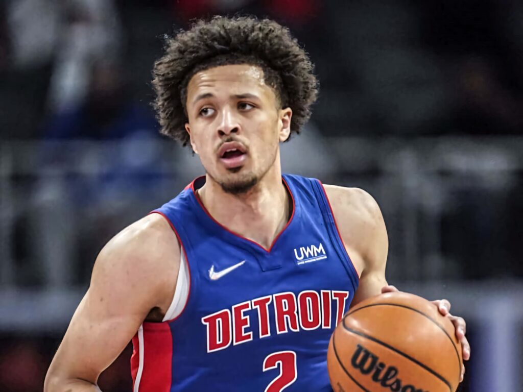 Cade Cunningham drives ball in Detroit Pistons blue jersey intense basketball game action wallpaper