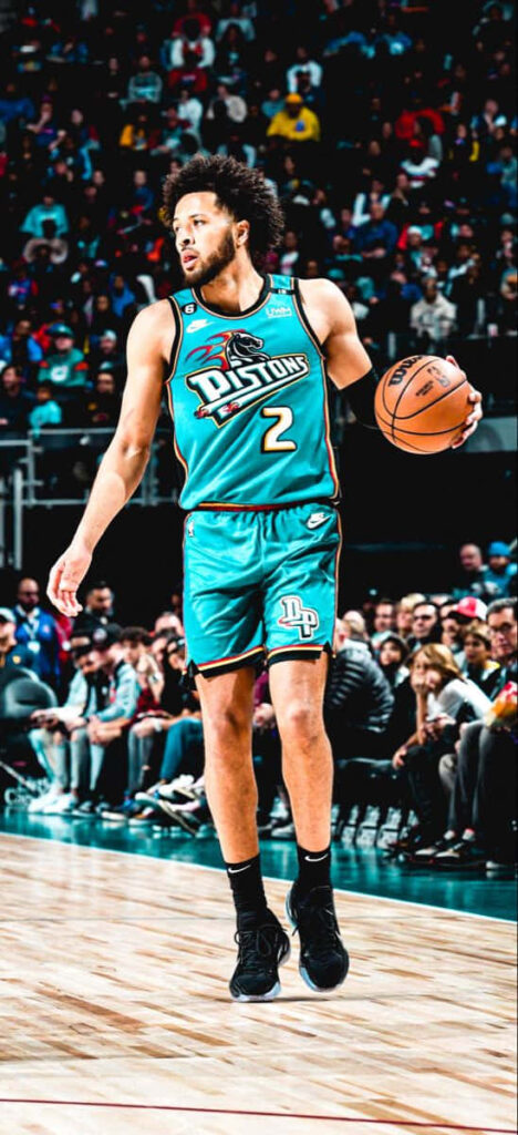 Cade Cunningham dribbling in Detroit Pistons teal retro uniform during live intense basketball game Wallpaper