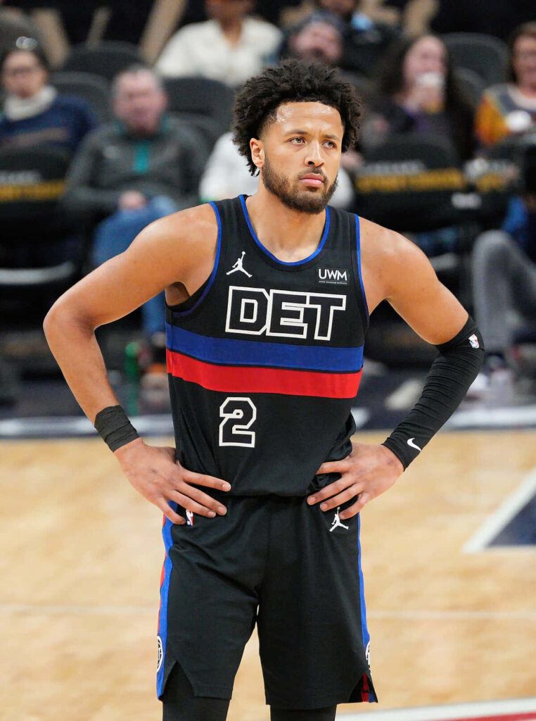 Cade Cunningham in Detroit Pistons black jersey on court focused basketball wallpaper background