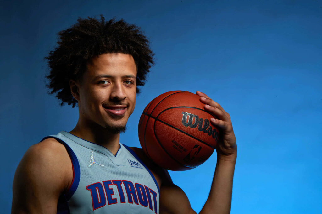 Cade Cunningham Detroit Pistons portrait wallpaper basketball jersey confident smile blue background