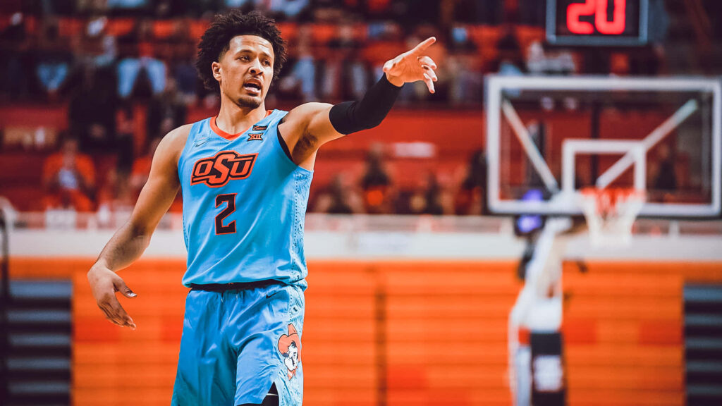 Cade Cunningham in light blue Oklahoma State jersey playing intense basketball game on court Wallpaper