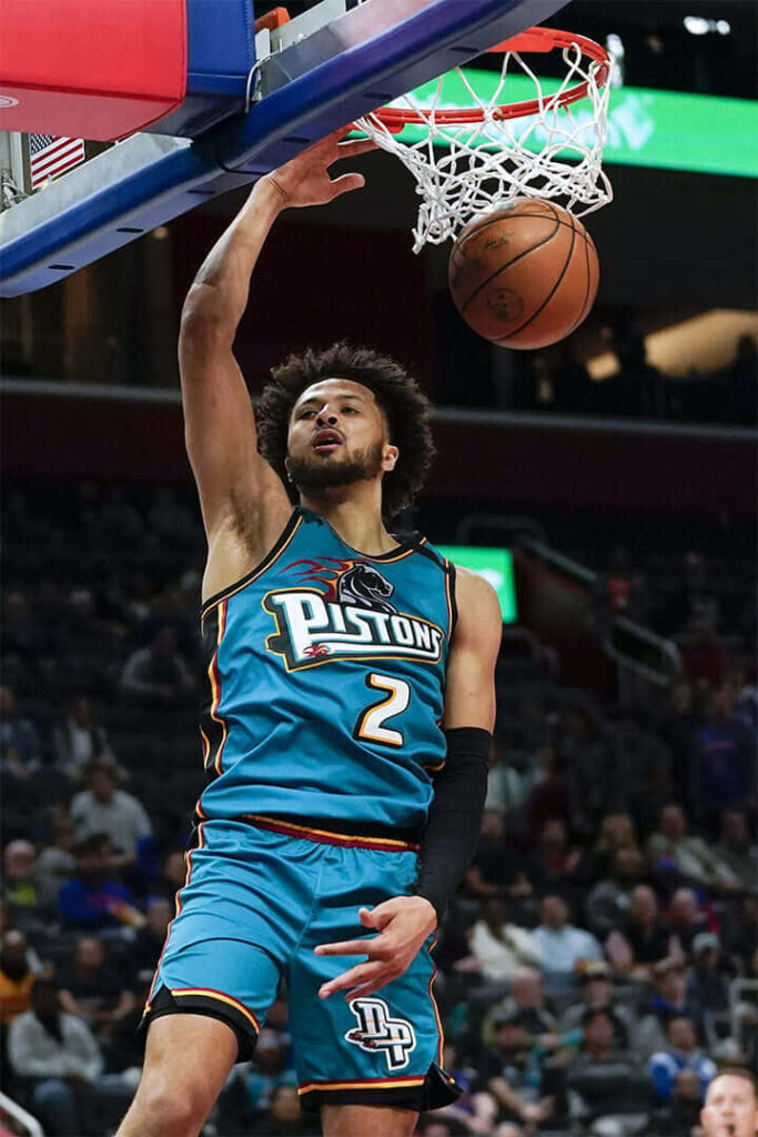 Cade Cunningham dunking in teal Detroit Pistons jersey dynamic basketball action wallpaper background
