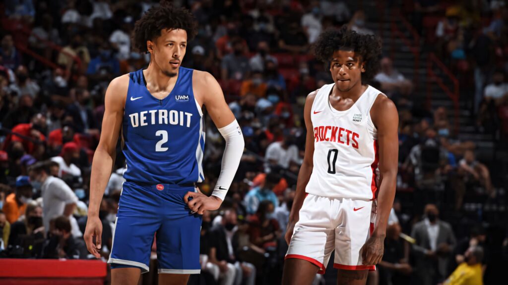 Cade Cunningham and Jalen Green in team jerseys on vibrant basketball court with arena backdrop Wallpaper