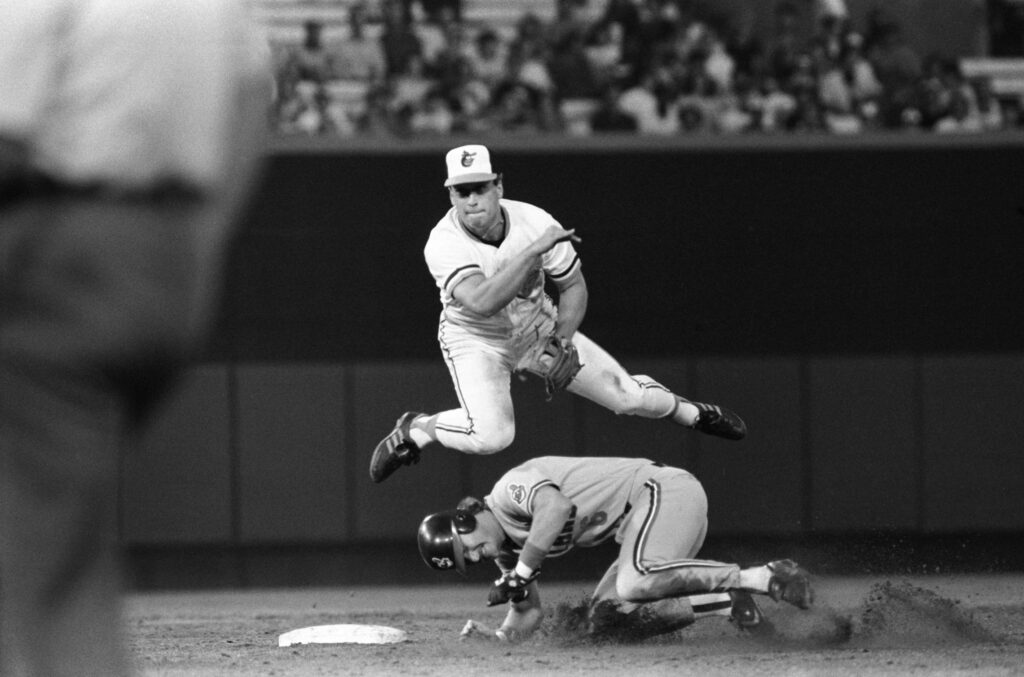 Cal Ripken Jr leaping over sliding runner black and white baseball action wallpaper background