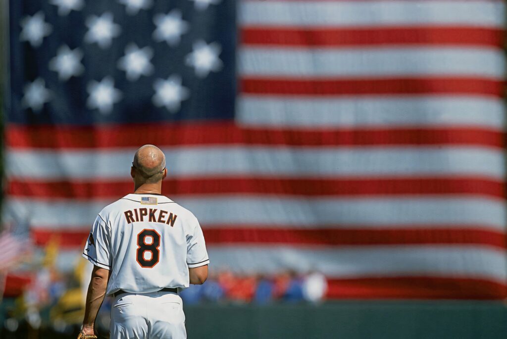 Cal Ripken Jr in Orioles jersey with US flag backdrop patriotic baseball heritage wallpaper