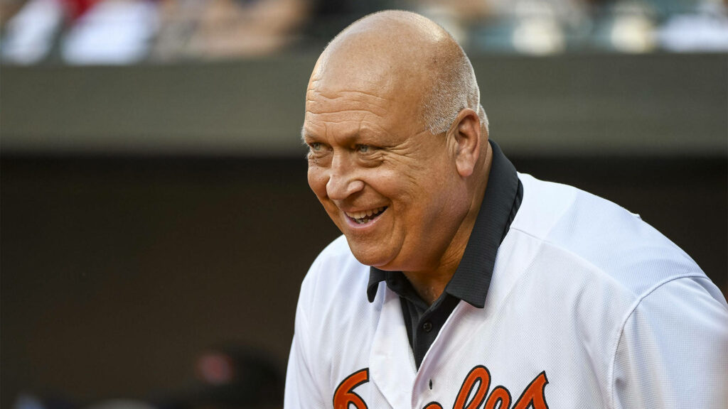 Cal Ripken Jr smiling in white Orioles jersey with stadium background legendary baseball icon wallpaper