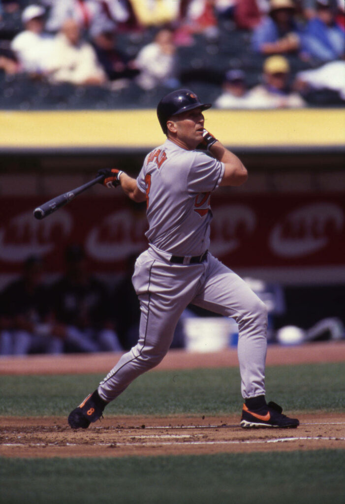 Cal Ripken Jr mid-swing in classic Orioles uniform vibrant stadium baseball action wallpaper