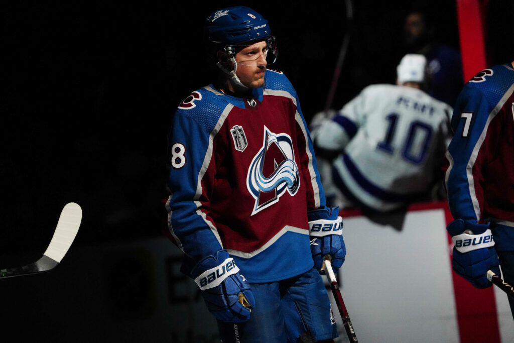 Cale Makar in Colorado Avalanche jersey under spotlight showing intense focus and determination Wallpaper