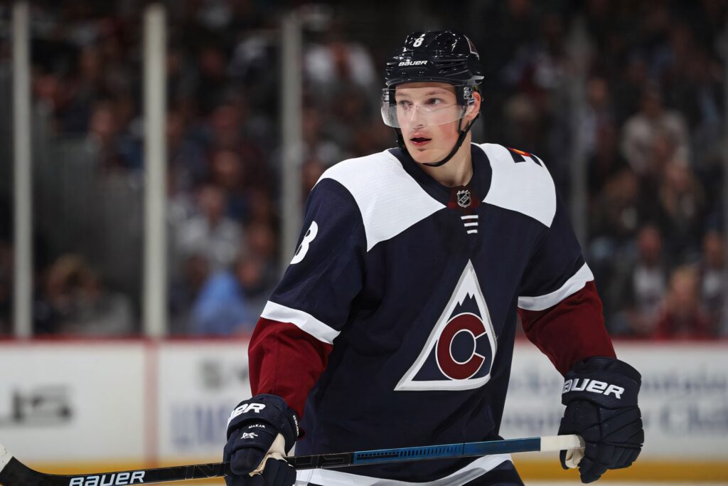 Cale Makar in dark blue Colorado Avalanche uniform poised mid-game intense hockey action wallpaper
