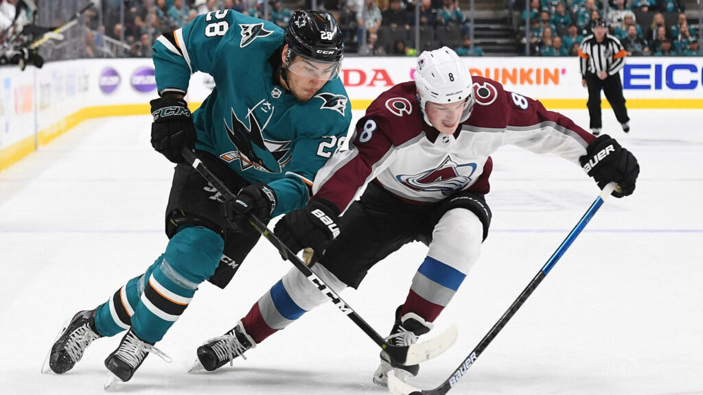 Cale Makar and Timo Meier intense NHL faceoff dynamic hockey action vibrant team colors wallpaper