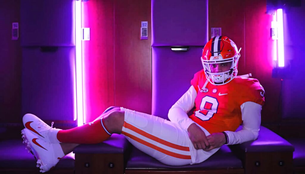 Caleb Williams in team uniform reclines in neon lit locker room vibrant football wallpaper background