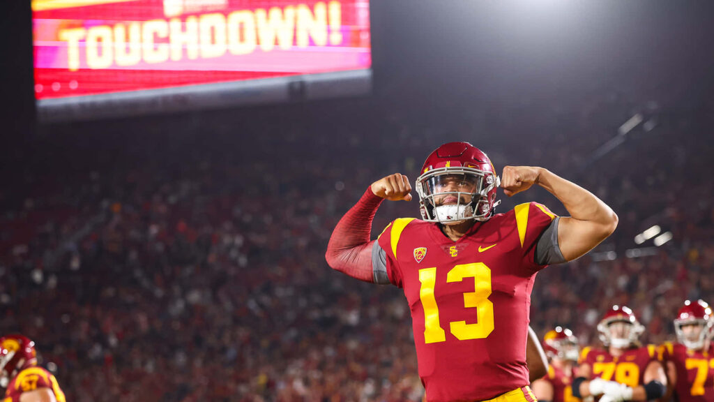Caleb Williams celebrates USC touchdown in red and gold uniform at vibrant football stadium Wallpaper