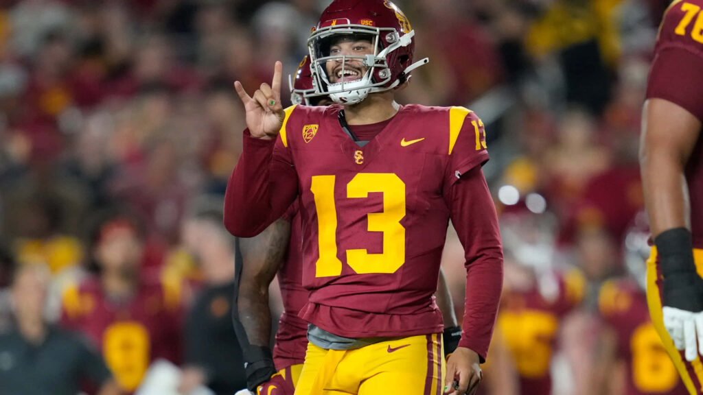 Caleb Williams in USC Trojans uniform number 13 confidently signals play on football field Wallpaper