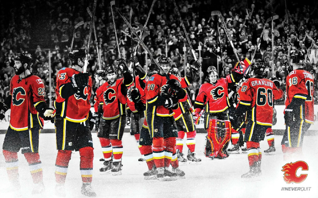 Calgary Flames hockey players in red yellow celebrate on ice with Flames logo and NeverQuit hashtag Wallpaper