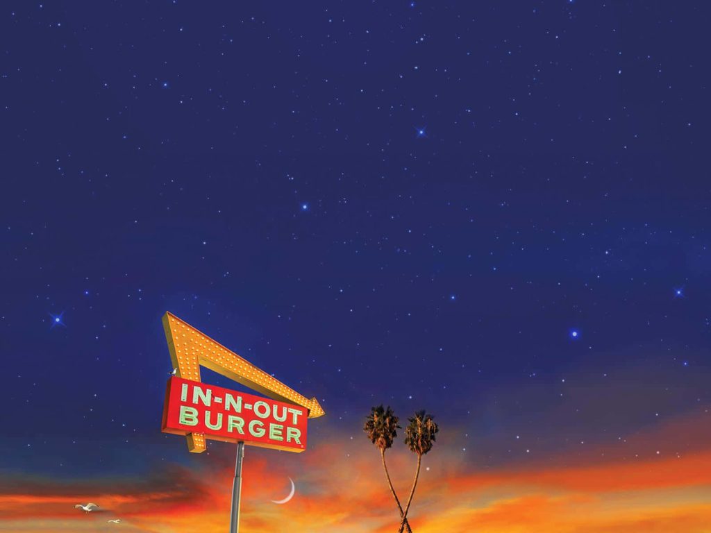 In-N-Out Burger yellow arrow sign with palm trees and starry twilight sky wallpaper background