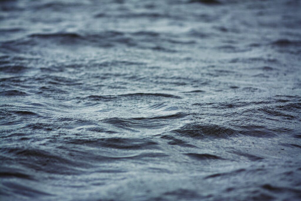 Calm sea with gentle ripples in cool blue tones creating a serene natural wallpaper background