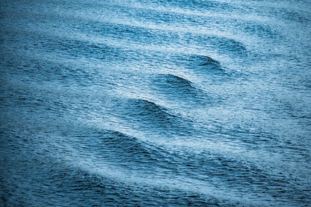 Calm blue sea waves with gentle ripples smooth texture serene ocean wallpaper background
