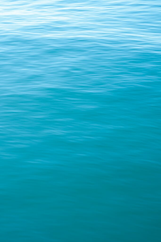 Calm blue water surface with gentle ripples minimalist wallpaper background for relaxation